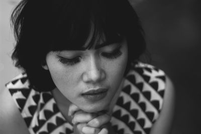 High angle close-up of young woman praying