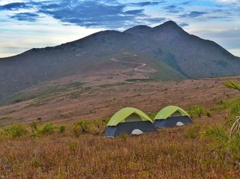 Scenic view of tent on mountain against sky