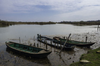 Boat moored in lake against sky