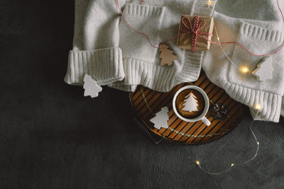 Christmas cup of coffee with sweater and christmas decorations.