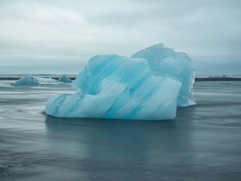 Ice floating on sea against sky