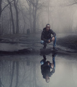 Full length portrait of man in puddle during rainy season