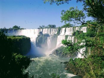 Scenic view of waterfall against sky
