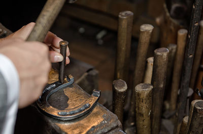 Close-up of man working on horseshoe