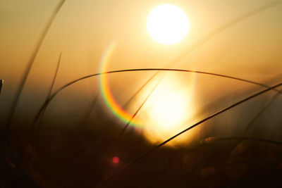 Close-up of illuminated yellow lights against sunset sky