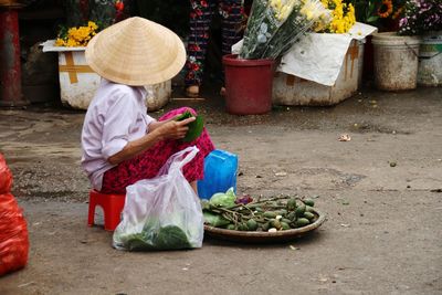 Midsection of woman sitting at market stall