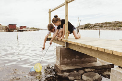 Happy brother and sister fishing at sea during summer vacation