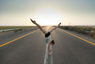 Rear view of woman jumping on road