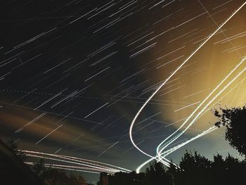 Low angle view of illuminated trees against sky at night