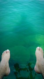 Low section of man swimming in water