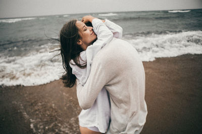 Woman lying down on sand at beach