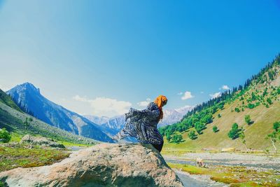 Man against mountain range against clear blue sky