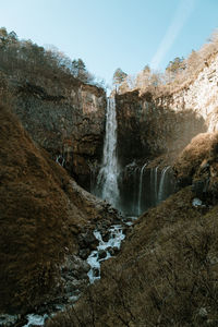 Scenic view of waterfall against sky