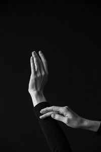 Close-up of woman hand over black background