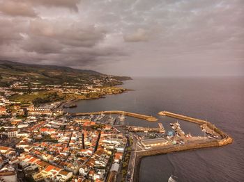 High angle view of cityscape by sea against sky