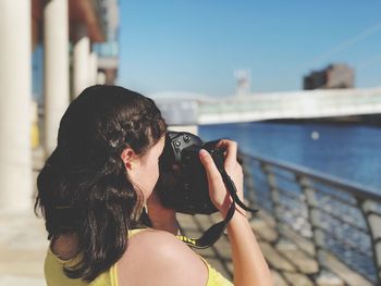 Portrait of woman photographing outdoors