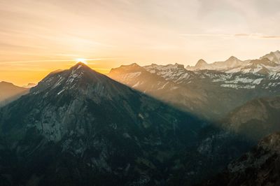 Scenic view of snowcapped mountains against sky during sunset