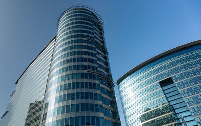 Low angle view of modern buildings against clear blue sky