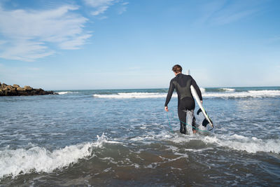 Full length of man standing on beach against sky