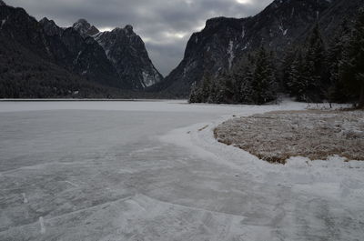 Scenic view of lake by mountains against sky