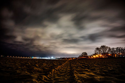 Scenic view of illuminated field against sky at night