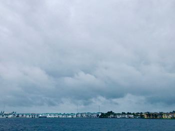 Scenic view of sea by buildings against sky