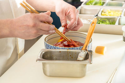 Midsection of woman having food in kitchen