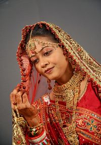 Close-up of smiling young bride standing against wall