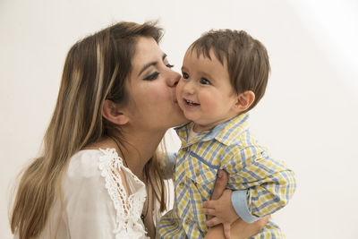 Close-up of mother and daughter against white background
