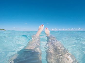 Low section of man in swimming pool against sea