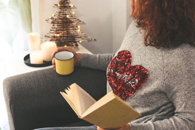 Rear view of woman with christmas tree at home