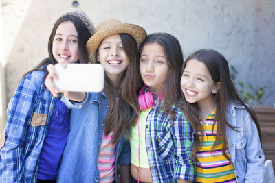 Portrait of a smiling young woman using phone