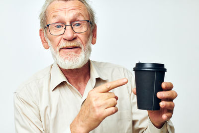 Young man drinking coffee against white background