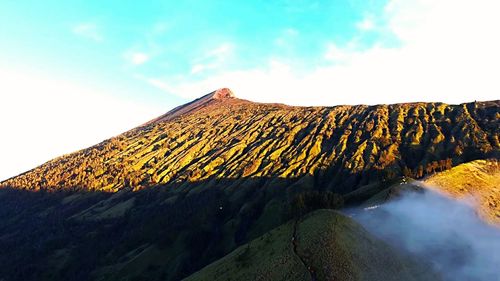 Low angle view of volcanic mountain against sky