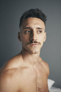 Portrait of a young boy with a moustache on a grey background