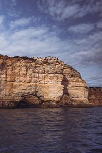 Rock formations by sea against sky