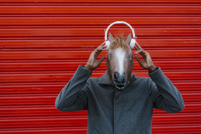 Portrait of man standing against red wall