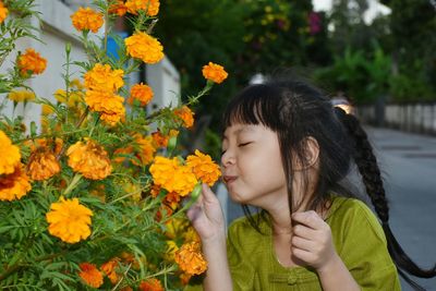 Close-up of smiling girl with yellow flowers