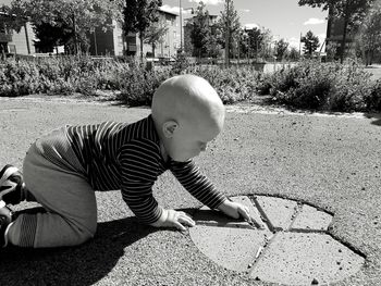 Side view of baby boy playing on road
