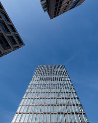 Low angle view of modern building against blue sky