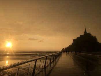 Mont saint-michel scenic view of sea against sky during sunset, after rain