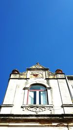 Low angle view of old building against clear blue sky