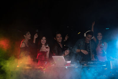 Happy people dancing in nightclub