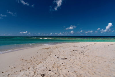Scenic view of beach against blue sky