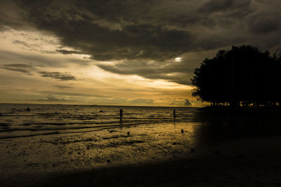 Scenic view of beach against sky at sunset