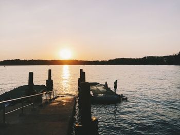 Pier over sea against sky during sunset