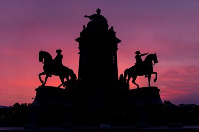 Low angle view of silhouette statue against sky during sunset