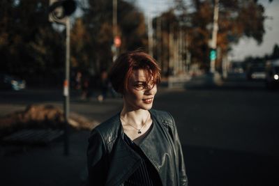 Portrait of young woman looking at city