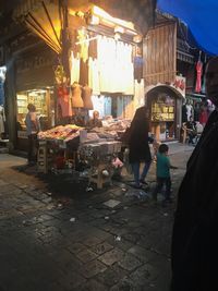 People at market stall at night