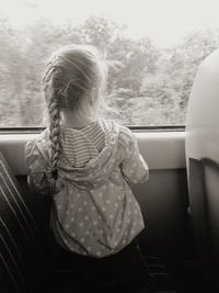 Rear view of girl seen through car window